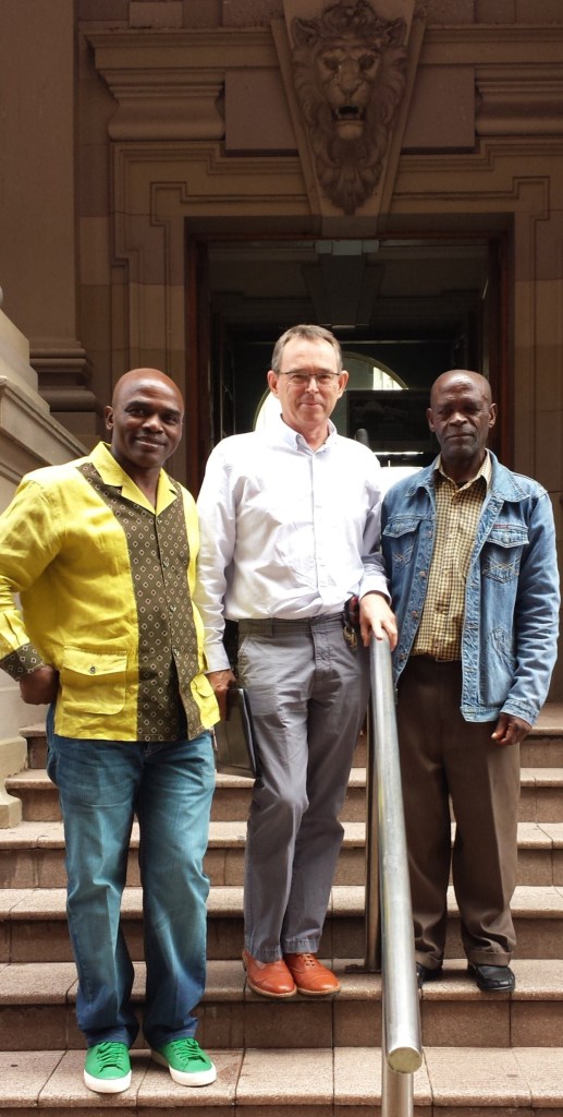 John Makwicana on the far right next to AeT Co-founders, Richard Dobson and Patrick Ndlovu outside the High Court after the Court victory. Photo: LRC.